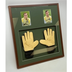 Pair of 1990s Leeds United goalkeeper's gloves signed by Nigel Martyn and Paul Robinson, mounted in a wall hanging framed display with signed pictures of each player 60 x 55cm. Provenance: the vendor was a coach at the keepers' club Leeds United and the gloves were signed for him.