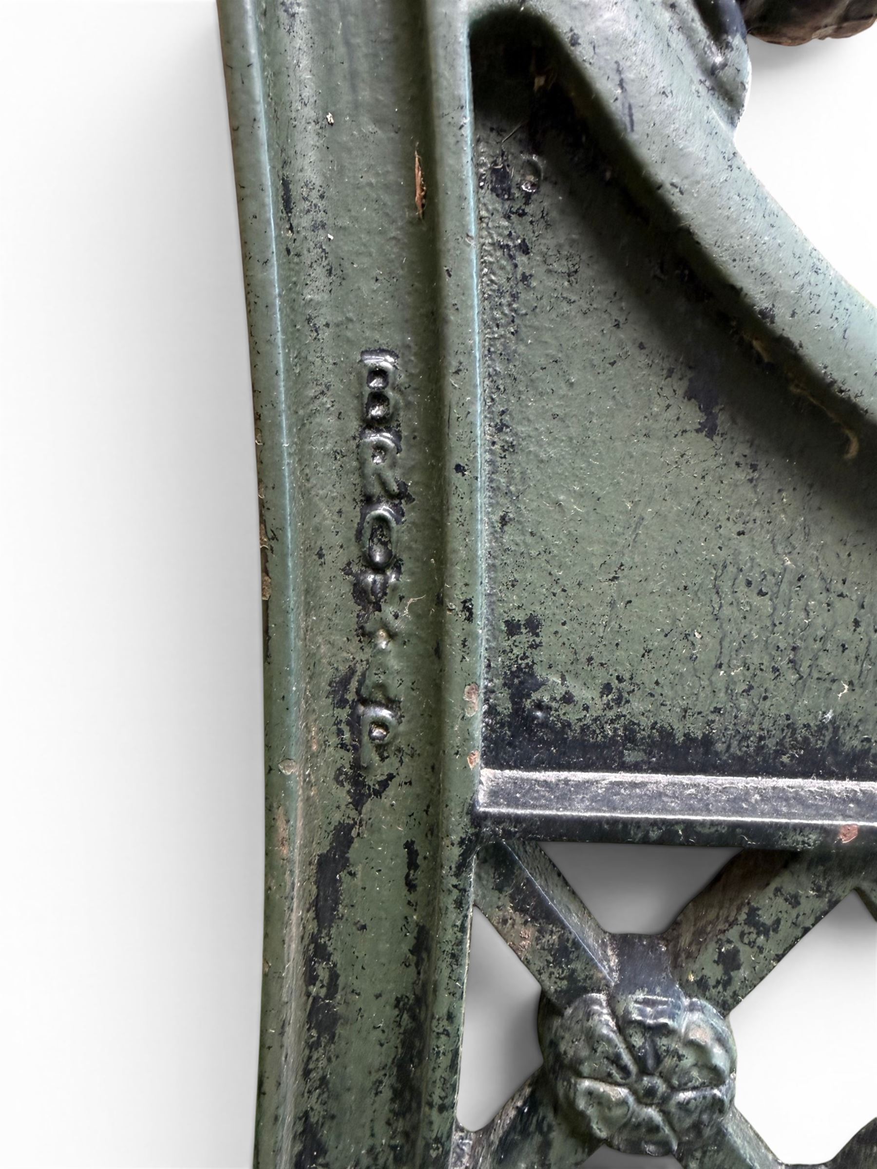 Neoclassical design cast iron and oak slatted garden bench, the twin end supports in the form of a Sphinx with acanthus carved knees and large paw feet, the pierced lattice bracket with Yorkshire rose motifs