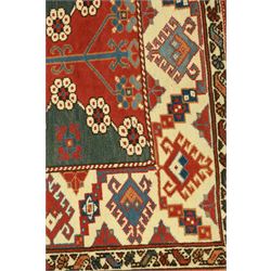 Caucasian Soumak rug, red madder field and teal panels, with bold stepped diamond medallion with hooked motifs and cruciform devices, and floral rosette clusters, surrounded by an ivory border with large hooked diamonds and stylized ram's horn devices, flanked by narrow guard stripes




