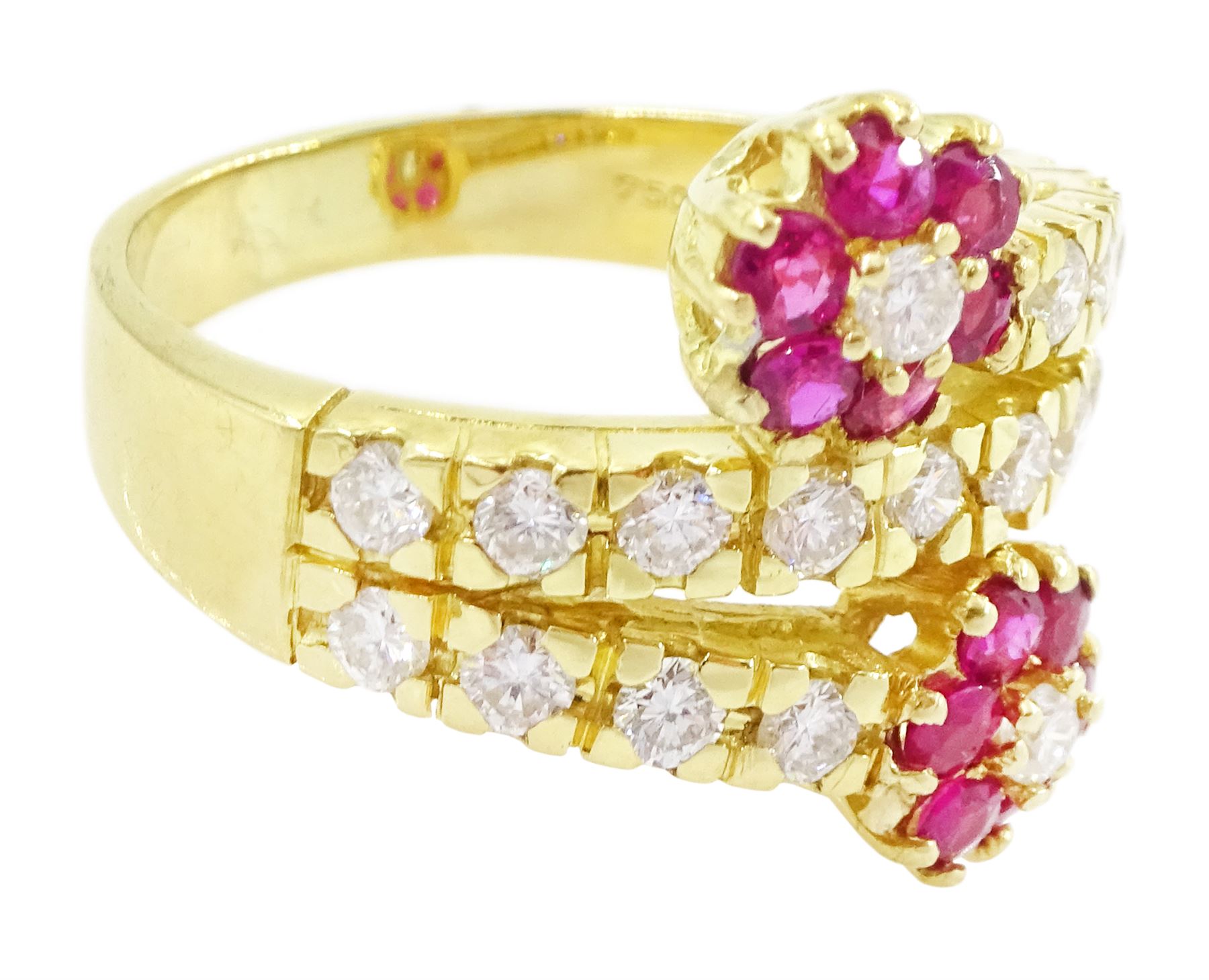 18ct gold ruby and diamond flower head crossover ring, two flowers each set with a single round brilliant cut diamond and six rubies, to diamond set stems and spaced by a row of nine diamonds, stamped 750, total diamond weight approx 0.55 carat