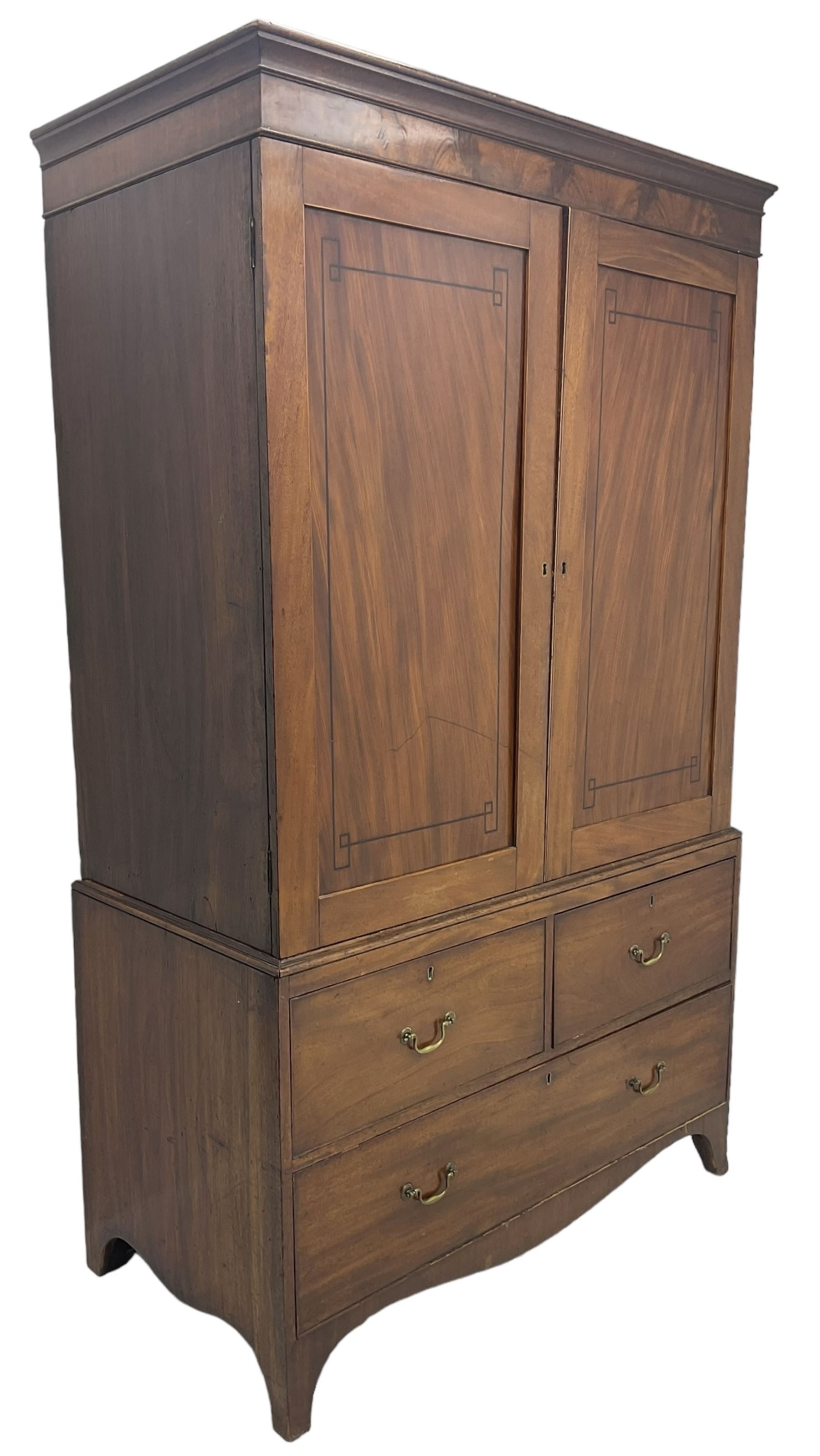 19th century mahogany linen press, projecting moulded cornice over figured frieze, enclosed by two panelled doors with geometric stringing, fitted with two short and one long cock-beaded drawers, on shaped apron and splayed bracket feet