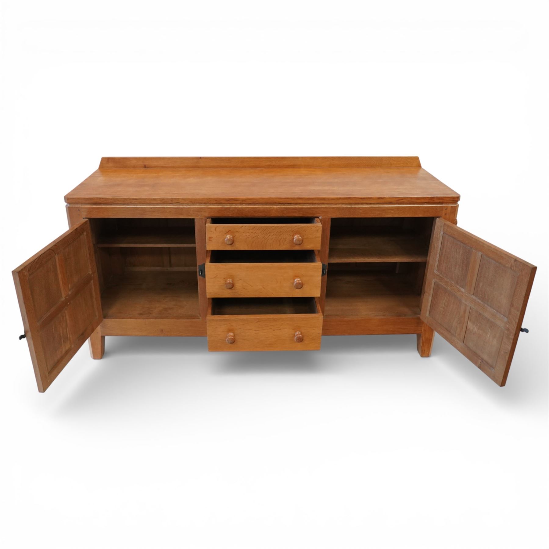 Rabbitman - oak sideboard adzed top with galleried top, with three graduating drawers to the centre, flanked by two panelled and lightly adzed doors, iron latches and hinges, raised on tapered stile supports, with carved rabbit signature, by Peter Heap of Wetwang   
