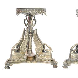 Pair of late 19th century silver plated tazza or centre piece stands, each of trefoil form upon acanthus mounted square pad feet, rising to a central decorative stem flanked by three stylised swans, the open foliate scrolling upper section supporting a circular plate stand, H19cm