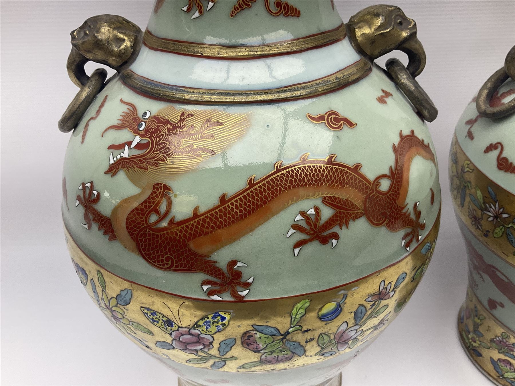 Pair of early 20th century Chinese vases decorated with dragons chasing a flaming pearl, with a gilt border of butterflies and floral sprigs, with Elephant head handles, H44cm 