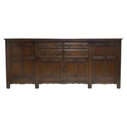 Ercol - dark elm dresser base, fitted with four drawers and four cupboards, enclosed by panelled doors