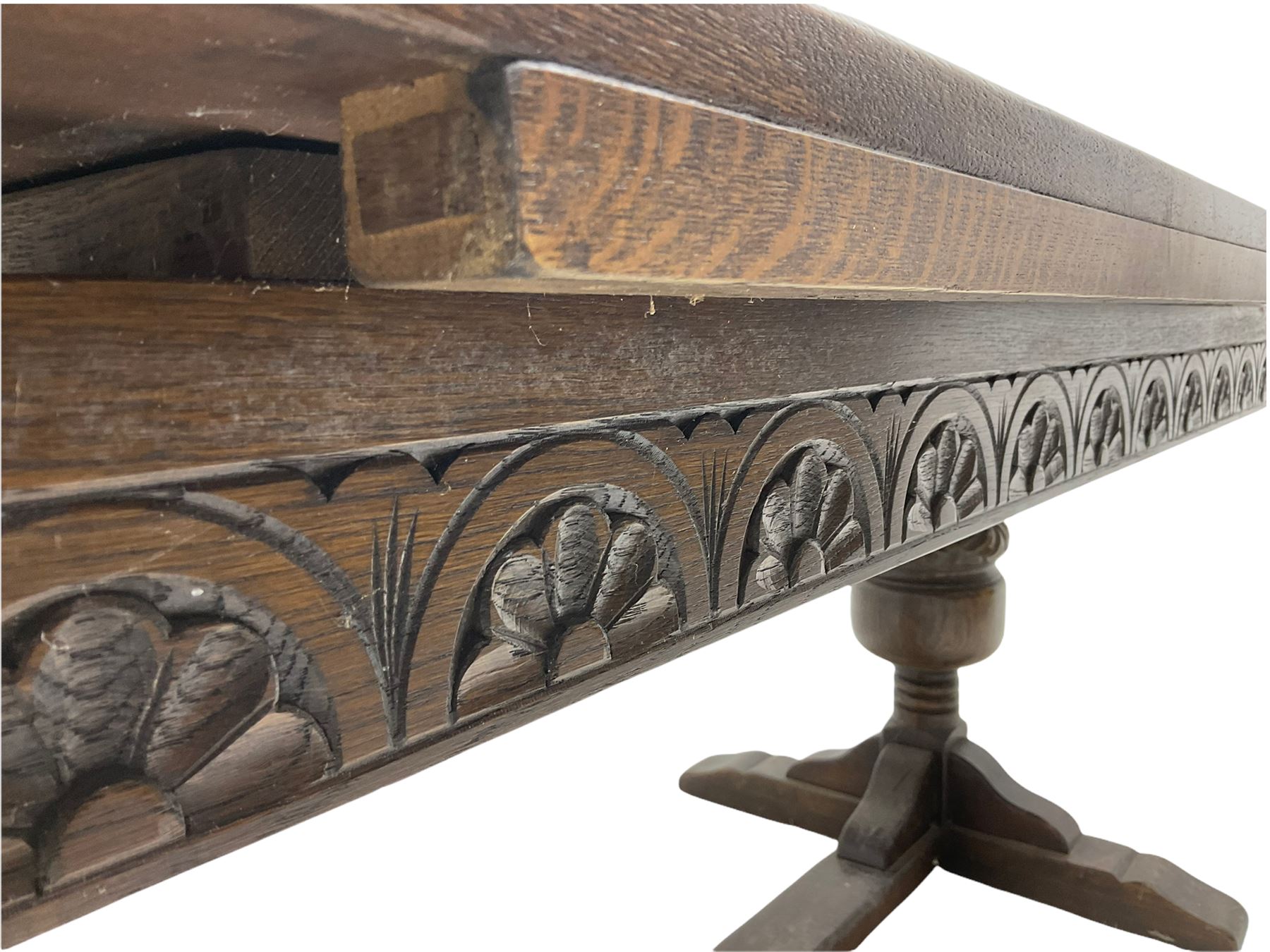 20th century oak drawer leaf extending dining table, two foliage carved baluster supports on sledge feet joined by floor stretcher 