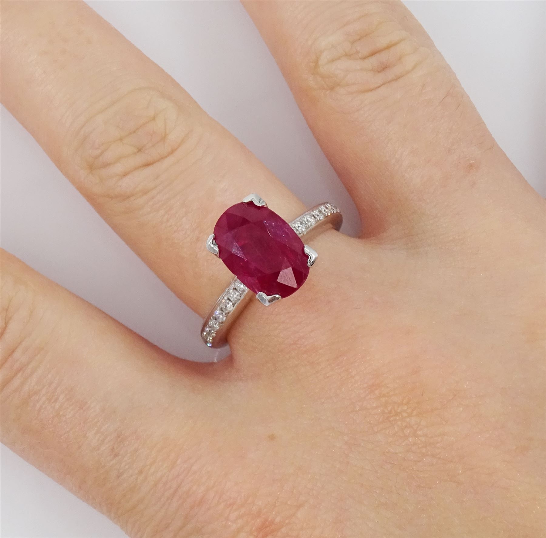 18ct white gold ruby and diamond ring, single oval cut ruby of approx 2.75 carat, with channel set diamond shoulders, hallmarked