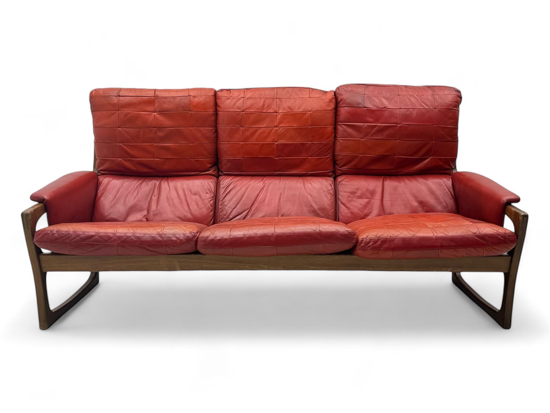 Folke Ohlsson for Gimson & Slater - mid-20th century Danish teak-framed sofa, red leather upholstery with patchwork design, raised on shaped teak side supports