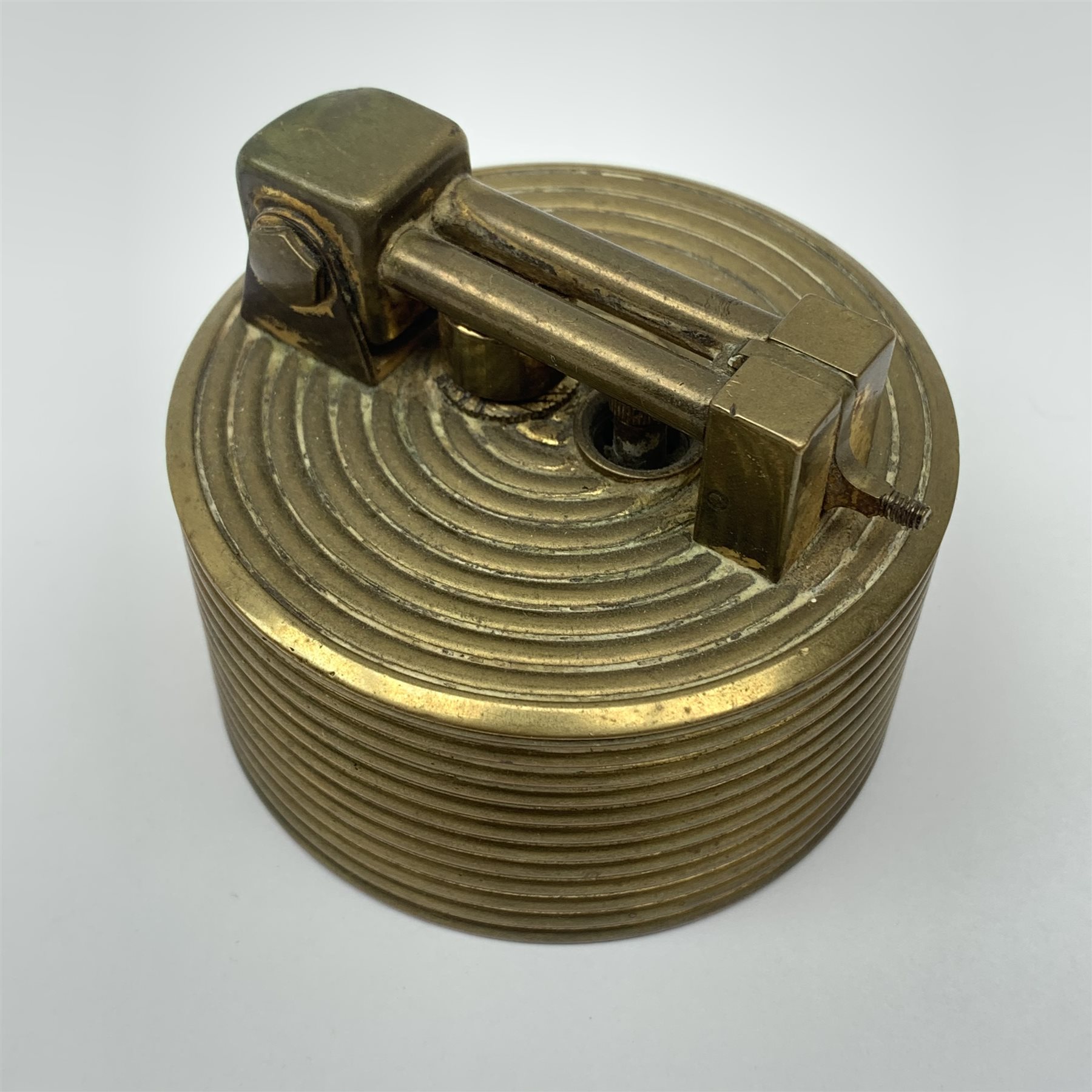 A Brilux Modele Depose Art Deco style brass table lighter, of cylindrical form with concentric ribbed decorated, marked beneath, H6cm. 