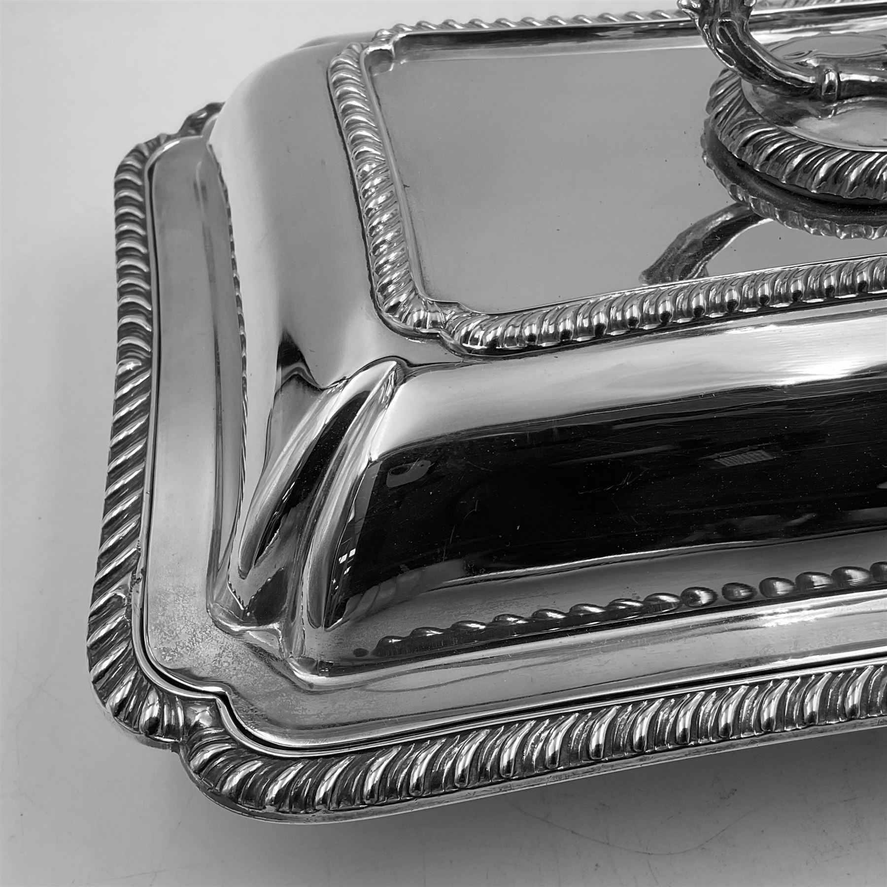 Early 20th century silver entree dish and cover, of rectangular form with shaped corners and oblique gadrooned borders to base and cover, the cover with loop 'bamboo' handle, hallmarked Thomas Bradbury & Sons Ltd, Sheffield 1930, including handle H10.5cm L24.5cm