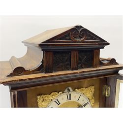Late 19th century walnut cased mantel clock, sloped arch and cavetto top pediment carved with flower heads, the brass dial with silvered Roman chapter ring decorated with shell and scroll cast spandrels, enclosed by bevel glazed and moulded door, the lower frieze carved with foliate scrolls, on stepped moulded base, twin train driven eight day movement with ting-tang strike, striking the hours and quarters, movement back plate stamped 'RMS' for Schnekenburger
