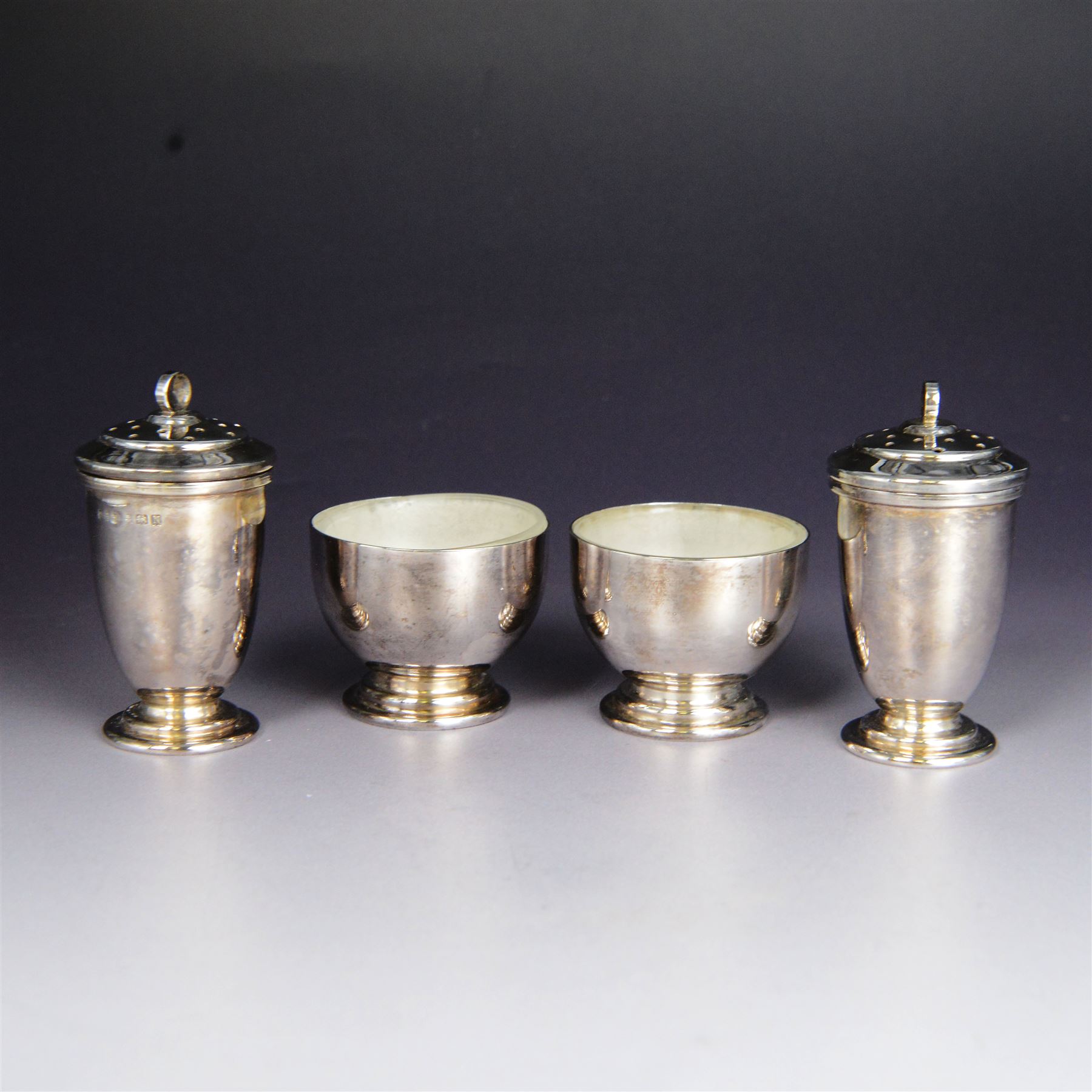 Art Deco silver five piece cruet set, comprising mustard pot, two pepper shakers and two open salts, hallmarked Hukin & Heath Ltd, Birmingham 1937, together with two silver salt spoons, hallmarked, mustard pot and salts with frosted glass liners, all contained within fitted tooled leather case
