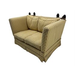 20th century Knole design two seat sofa, high back and double drop-arm joined by mahogany finials and ties, upholstered in camel ground fabric with red lozenge design, on turned supports with brass castors