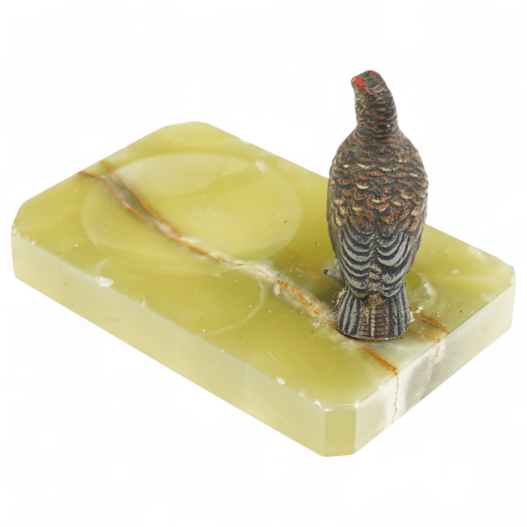 Cold painted bronze model of a grouse; mounted on an onyx ashtray base W11cm; together with an onyx cigarette box, W17cm, and horseshoe and perpetual calendar mounted on onyx slab, 205.cm x 14cm , each made out to Captain Charles Elsey upon his retirement from training Thoroughbred racehorses (3)