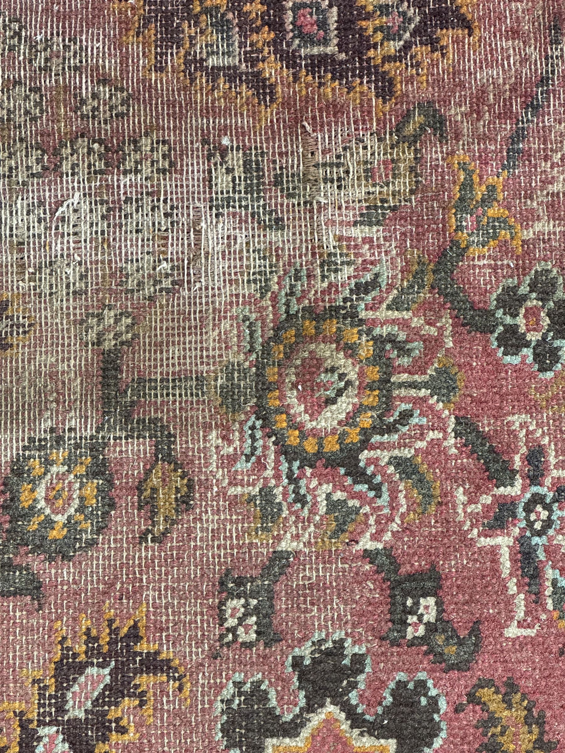 Belgian Sultan woollen ground rug, central navy field densely decorated with floral sprays and geometric patterns (192cm x 135cm); handwoven tribal terracotta ground rug (121cm x 71cm); Persian crimson ground runner, all over stylised floral and foliate motifs (266cm x 94cm)