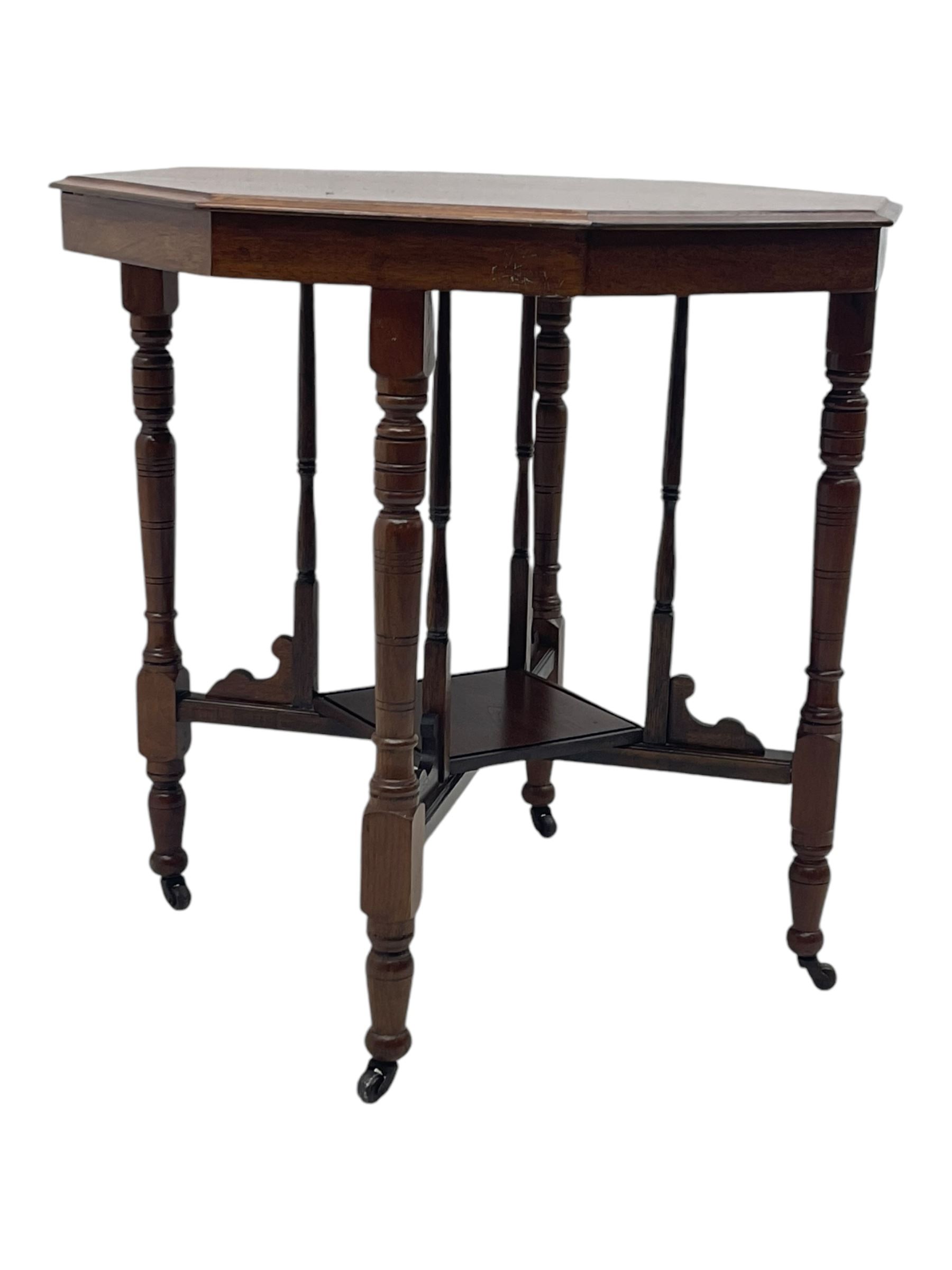 Victorian oak occasional table, octagonal top with bevelled edges, lower section fitted with a square undertier united by decorative shaped stretchers, on turned supports with castors