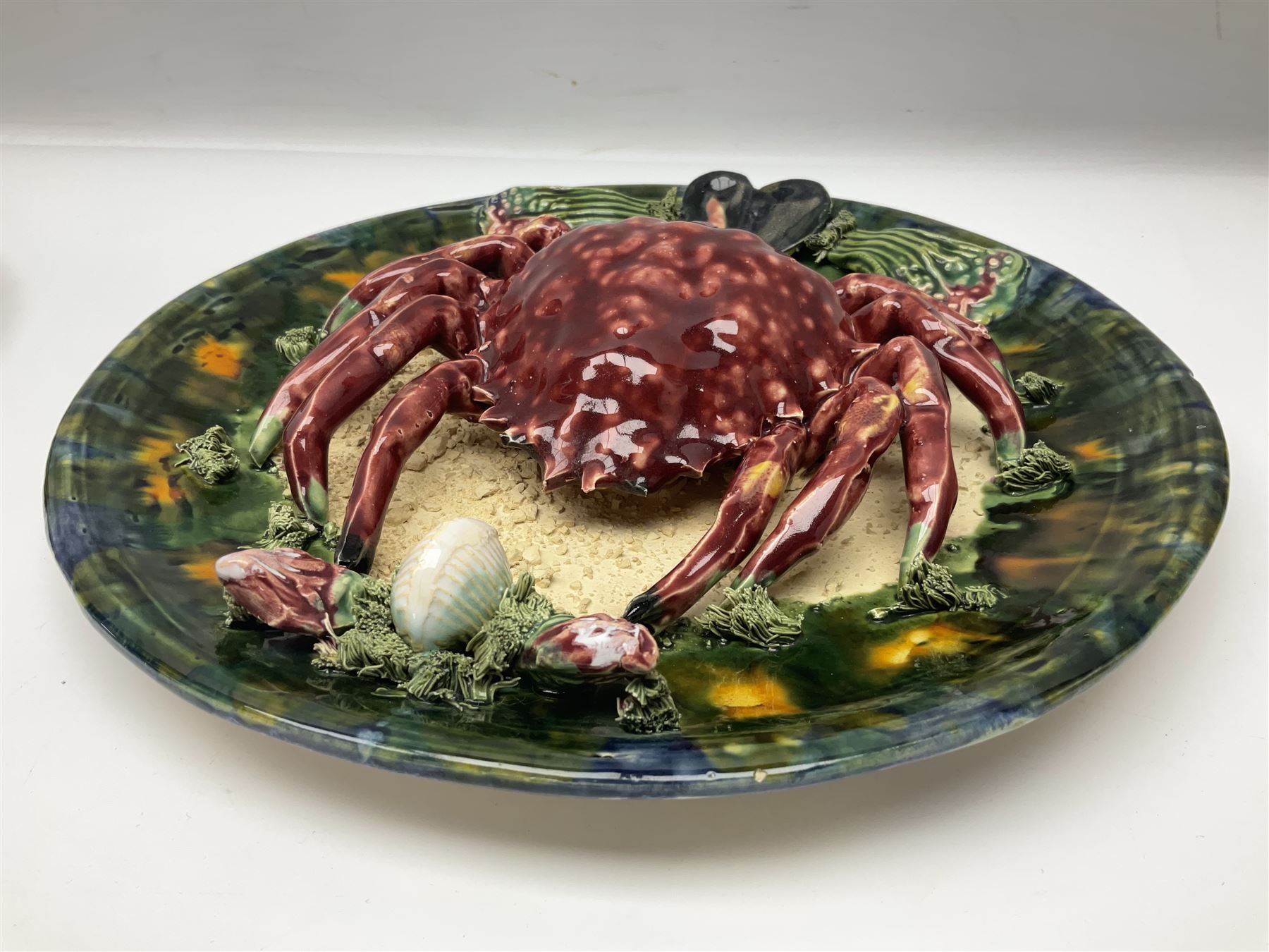 Two 20th Century Portuguese Palissy style Majolica wall plates, one depicting a crab, the other a lobster each to the centre modelled in relief surrounded by encrustations and shells, both with impress marks beneath, D32cm