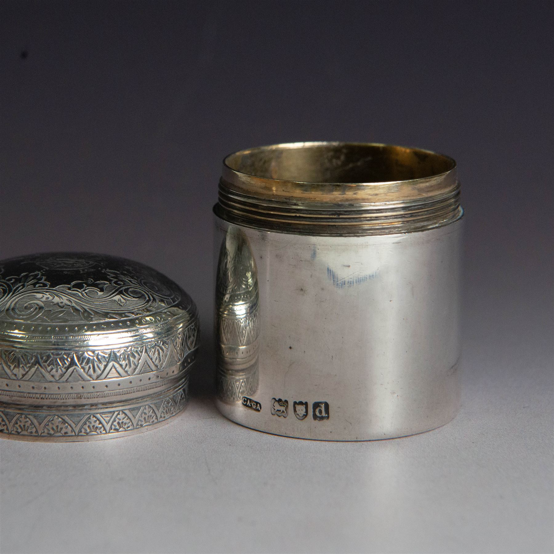 Late Victorian silver jar with cover, of cylindrical form with  domed cover engraved with initials, hallmarked Charles & George Asprey, together with a small ecclesiastical trinket box, engraved with cross to cover and with personal engraving beneath, hallmarked Edgar Ernest Davis, London 1944, taller jar H6cm