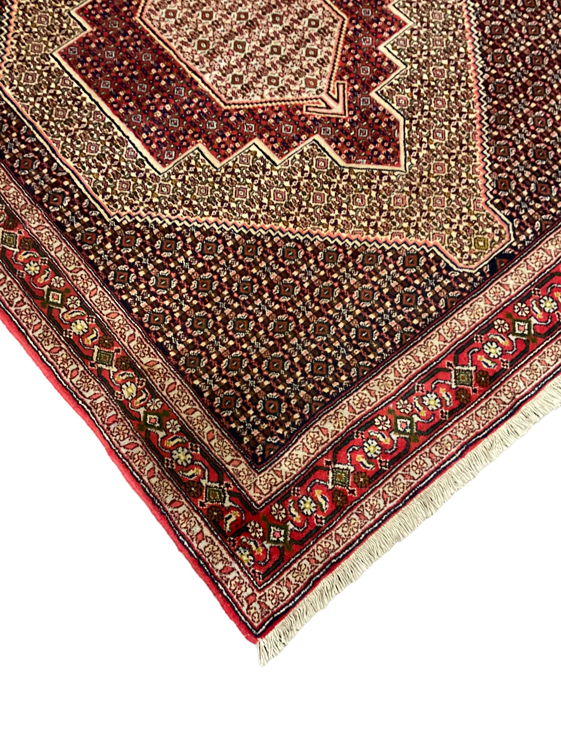Persian Hamadan rug, lozenge field and decorated with repeating Herati motifs, the band border with repeating design decorated with stylised plant motifs