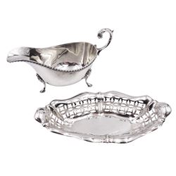 Mid 20th century silver sauce boat, of typical form with oblique gadrooned rim, and acanthus capped flying scroll handle, upon three hoof feet, hallmarked James Dixon & Sons Ltd, Sheffield 1956, including handle H8cm, together with an early 20th century silver dish, of shaped oval form with pierced sides, hallmarked Joseph Rodgers & Sons, Sheffield, date letter worn and indistinct, W16.5cm, approximate total weight 5.05 ozt (157 grams)
