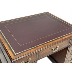 George III mahogany twin pedestal partner's desk, moulded rectangular caddy top with tooled leather inset, one side fitted with nine drawers and the opposing side fitted with single drawer, two false drawers and two panelled cupboards, ornate cast gilt metal handles and handle plates, on plinth base
