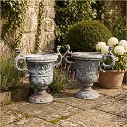 Impressive pair of early highly decorative lead garden urns, griffin handles with ornate decoration depicting cherubs and laurel wreath