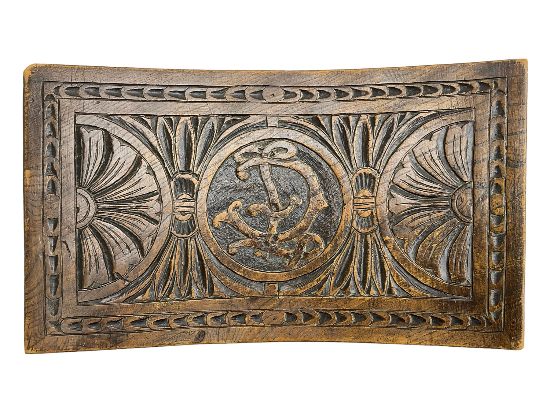 Late 19th century oak stool, rectangular dished top relief carved with floral lunettes and central insignia, on turned splayed supports