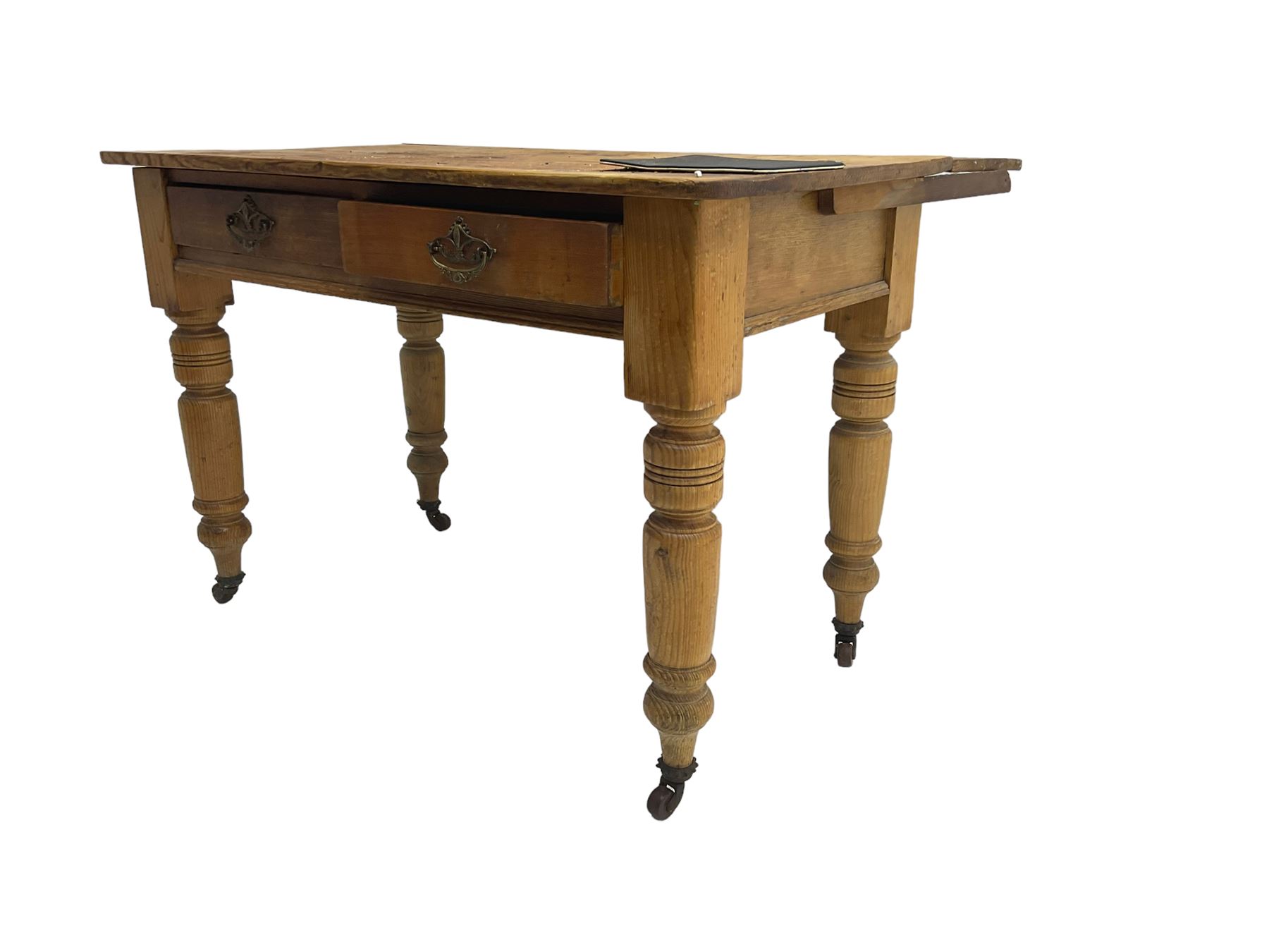 Traditional rustic pine dining table, rectangular top fitted with two drawers, raised on turned tapering supports on ceramic castors