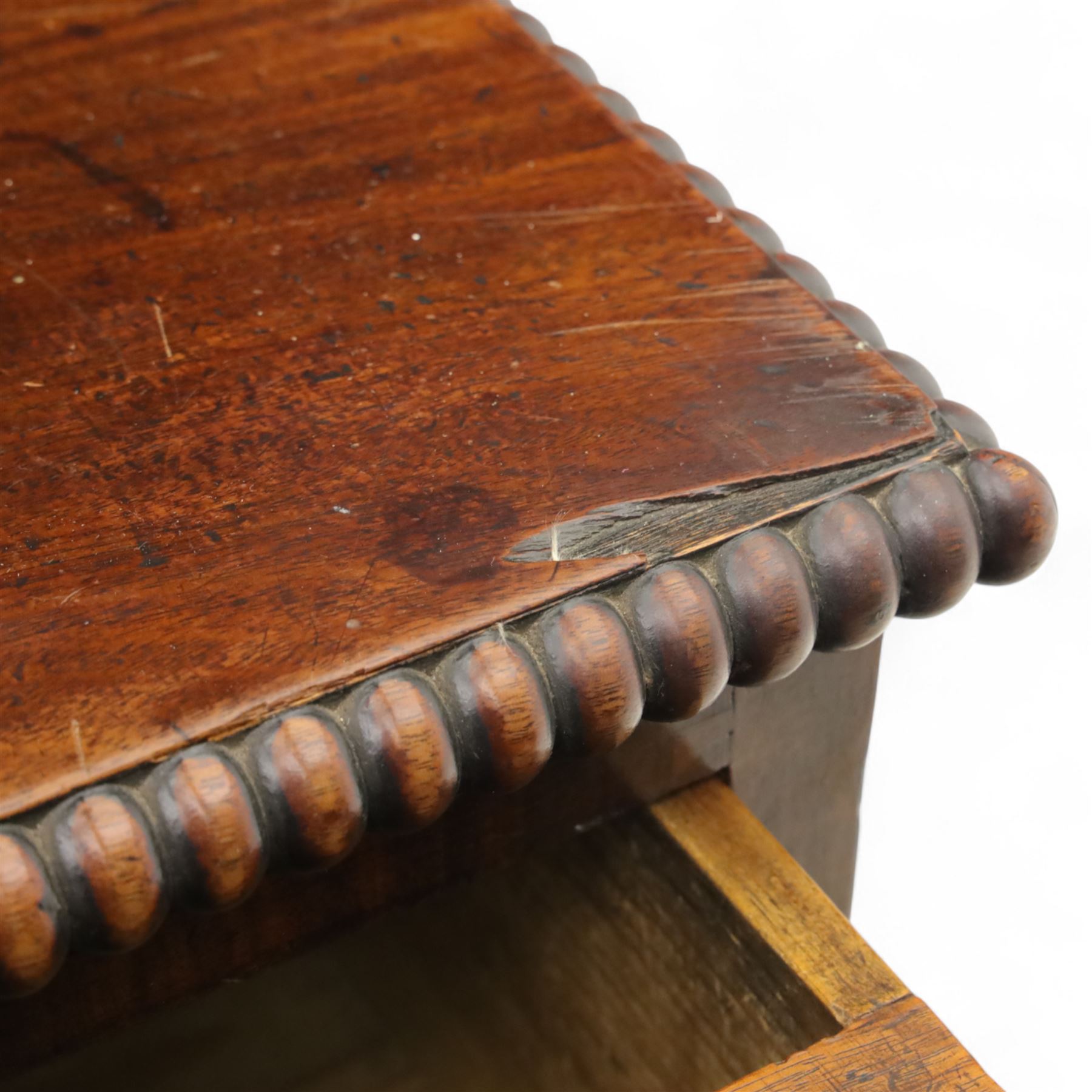 George III mahogany linen press, moulded cornice above a pair of panelled doors with gadrooned beading above a gadrooned edge over two short and three graduated drawers, with shaped apron, raised on sabre feet  