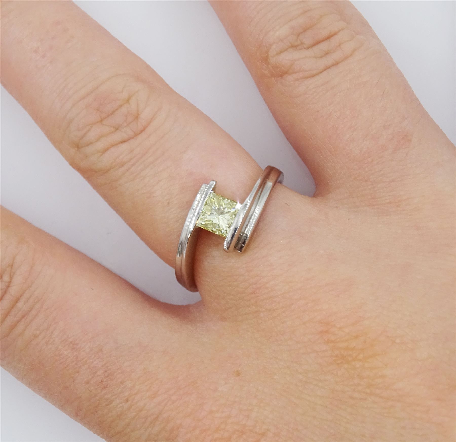 Platinum diamond ring, tension set with a single princess cut fancy yellow diamond of approx 0.60 carat, hallmarked