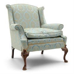 Georgian design carved mahogany framed wingback armchair, high wingback over sprung seat and loose cushion with rolled arms, upholstered in cyan ground gilt foliate damask fabric, on shell-carved cabriole supports with pad feet