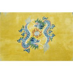 Modern Chinese hand-knotted wool pile carpet, golden field decorated with conforming dragons amidst stylized cloud scrolls enclosed by a Greek gey meander border, with cotton fringe ends 