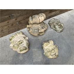 Four grotesque garden wall masks