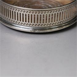 Silver bottle coaster, of circular form with turned wooden centre and pierced sides, hallmarked LGS, London 1977, together with two decanter labels, each with embossed grape vine decoration engraved Scotch and Sherry, hallmarked 