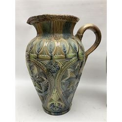 Early 20th century Royal Doulton stoneware vase, decorated with a stylized floral design below a wavy rim, monogrammed B.N, possibly for Bessie Newbery, H28cm, together with an early 20th century glazed jug, heavily carved throughout (2)