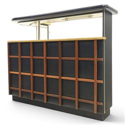 Barget of London - Mid 20th century L-shaped teak and black vinyl cocktail bar, shaped top with gilt metal banding and black cushioned edge over glazed upper section and open serving shelf, the reverse fitted with shelves, the front with applied lattice mouldings over black vinyl, on plinth base