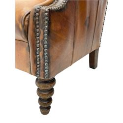 Laura Ashley - hardwood-framed armchair, traditional shape with arched cresting rail over rolled arms, upholstered in buttoned brown leather with studded work, on turned front feet (W76cm, W95cm, D84cm); together with matching rectangular footstool (53cm x 34cm, H29cm)