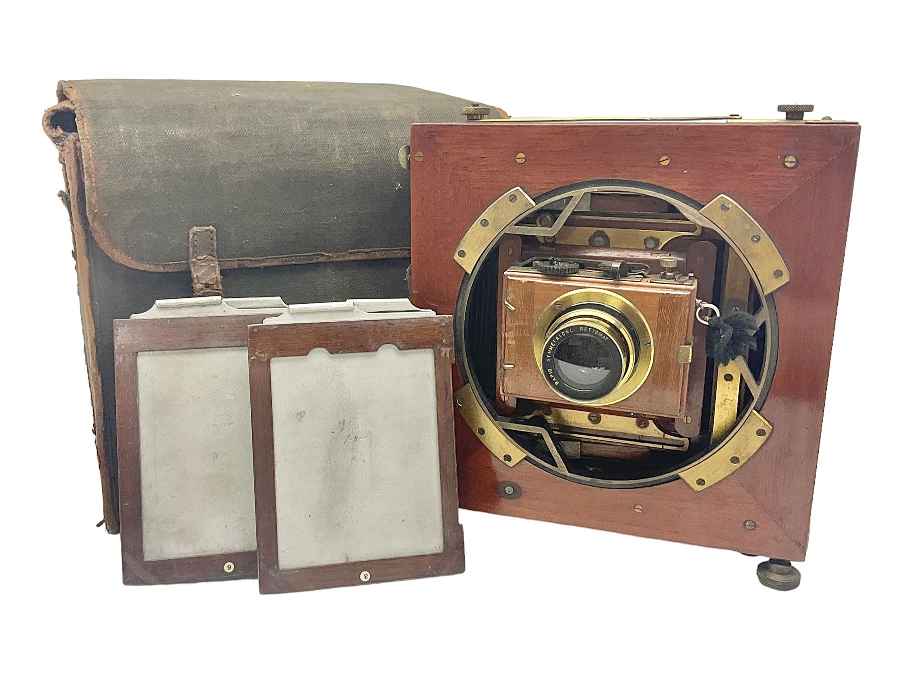 Folding plate camera in mahogany and lacquered brass, with Rapid Symmetrical Reetigmat len and two dark slides in canvas case
