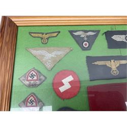 Framed display of thirty-four WWII German cloth badges including Luftwaffe pilot, Paratrooper, Afrikakorps cuff title, sleeve insignia for 'SS' Foreign Volunteers, various breast eagles including Luftwaffe, Army etc, RAD badges, Party Armband, rank and trade insignia, cap insignia etc; 40 x 50cm in modern pine frame
