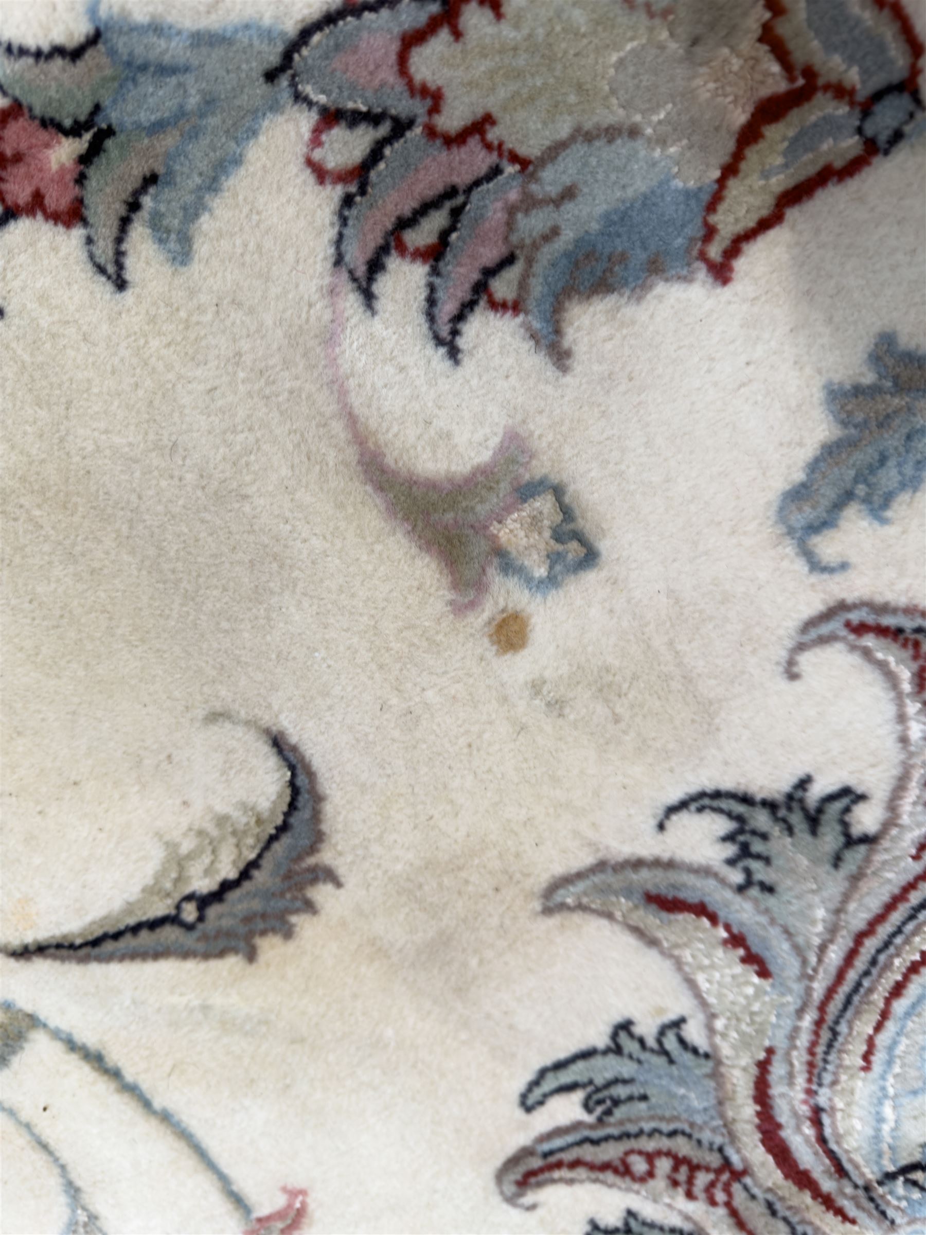 North East Persian Kashmar hand-knotted rug, ivory field with an all-over design of linked floral medallions and scrolling vines with a central circular medallion enclosed by multiple borders and a main broad madder field with palmettes and arabesques, 248cm x 145cm