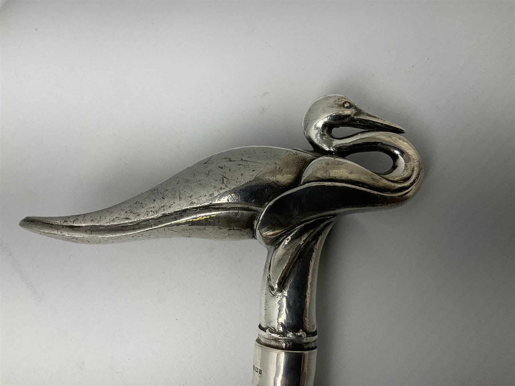 Art Deco style Italian 'Rivestito' covered silver walking stick handle, modelled in the form of a swan, stamped 'R', upon a silver collar hallmarked Birmingham 1986, makers mark DH-L, and hardwood shaft, L96cm

Provenance by vendor repute: 
This walking cane comes from a private collection amassed by the current vendors mother who was an Antique dealer specialising in walking sticks, working at the Portobello Road Antique Market in London for over forty years. 
In 1988 the prop crew from LWT (now ITV) visited Portobello Road looking for, amongst other items, a signature stick for David Suchet to use in his portrayal of Agatha Christie's Poirot. 
At the time this particular walking stick was one of five in possession. The prop crew chose and purchased another of the five which was then used by Suchet throughout all seventy episodes of the much loved series. 
Following the conclusion of the series Suchet was gifted his particular cane, which has been loaned to and can now be seen at the Agatha Christie Gallery at the Torquay Museum. 
