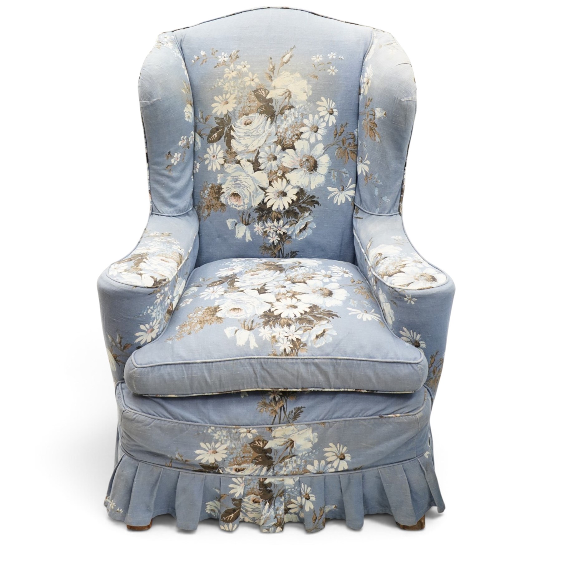 Pair of Queen Anne wingback armchairs, high back over out-swept arms, raised on ball-and-claw feet, upholstered in sky-blue ground floral chintz loose upholstery with pleated skirt and squab cushion
