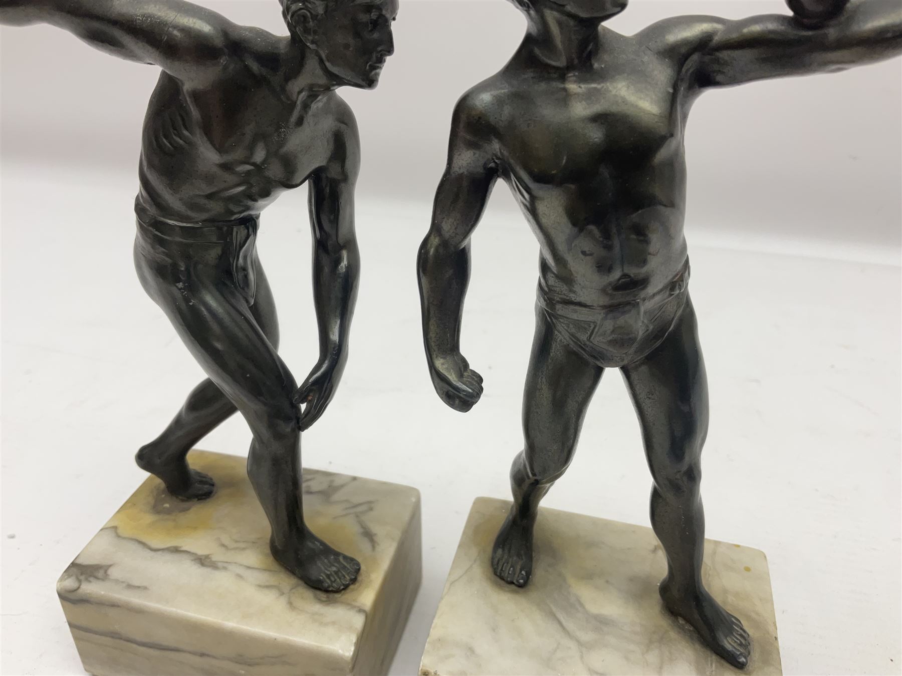 Bronzed model of the discus thrower and another of a episkyros player, both raised upon retangular plinths, H18cm