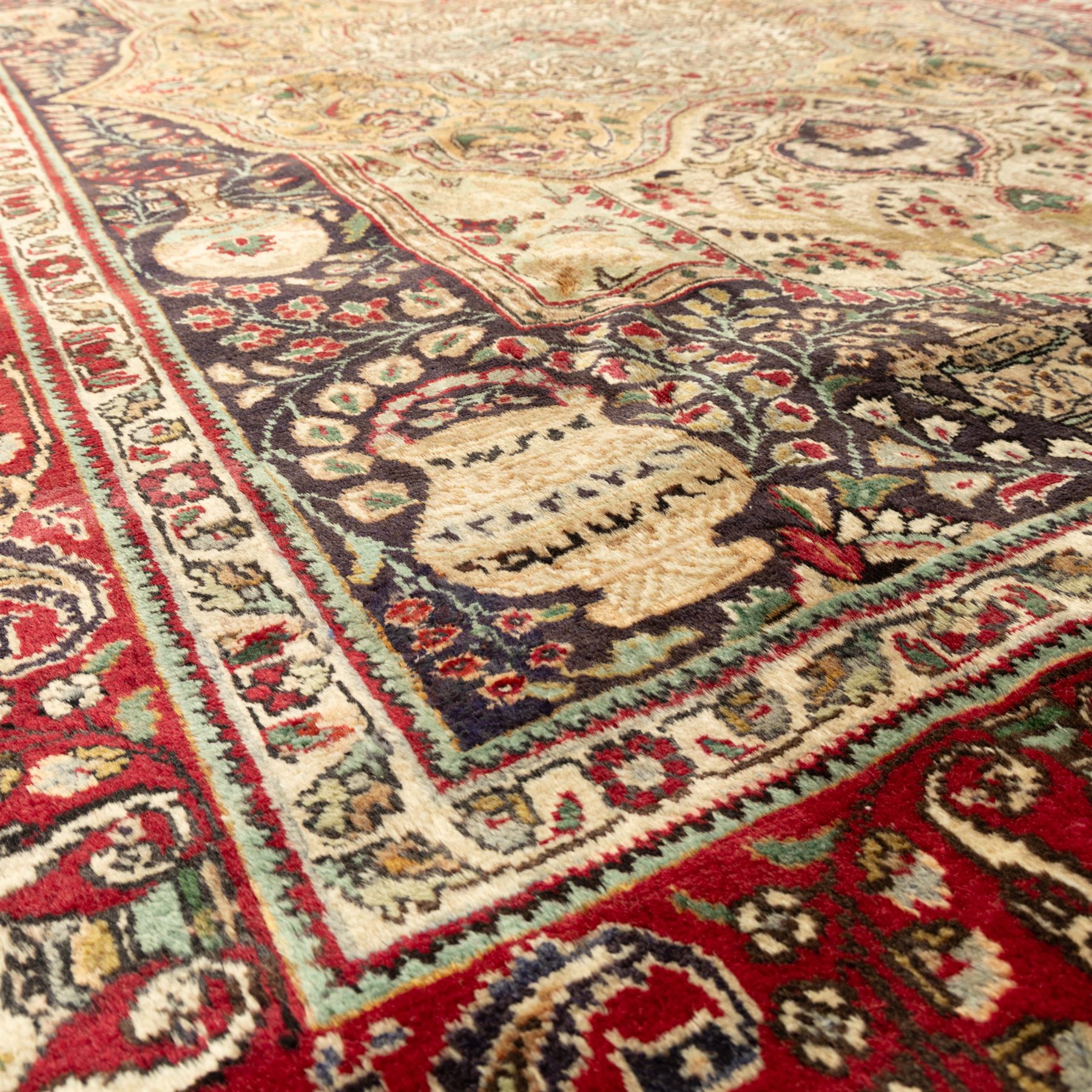 Azerbaijan rug, intricate central medallion in muted golds and greens surrounded by navy panels filled with boteh and floral designs, enclosed by a red main border featuring stylised boteh motifs, woven in the Caucasus region of Azerbaijan