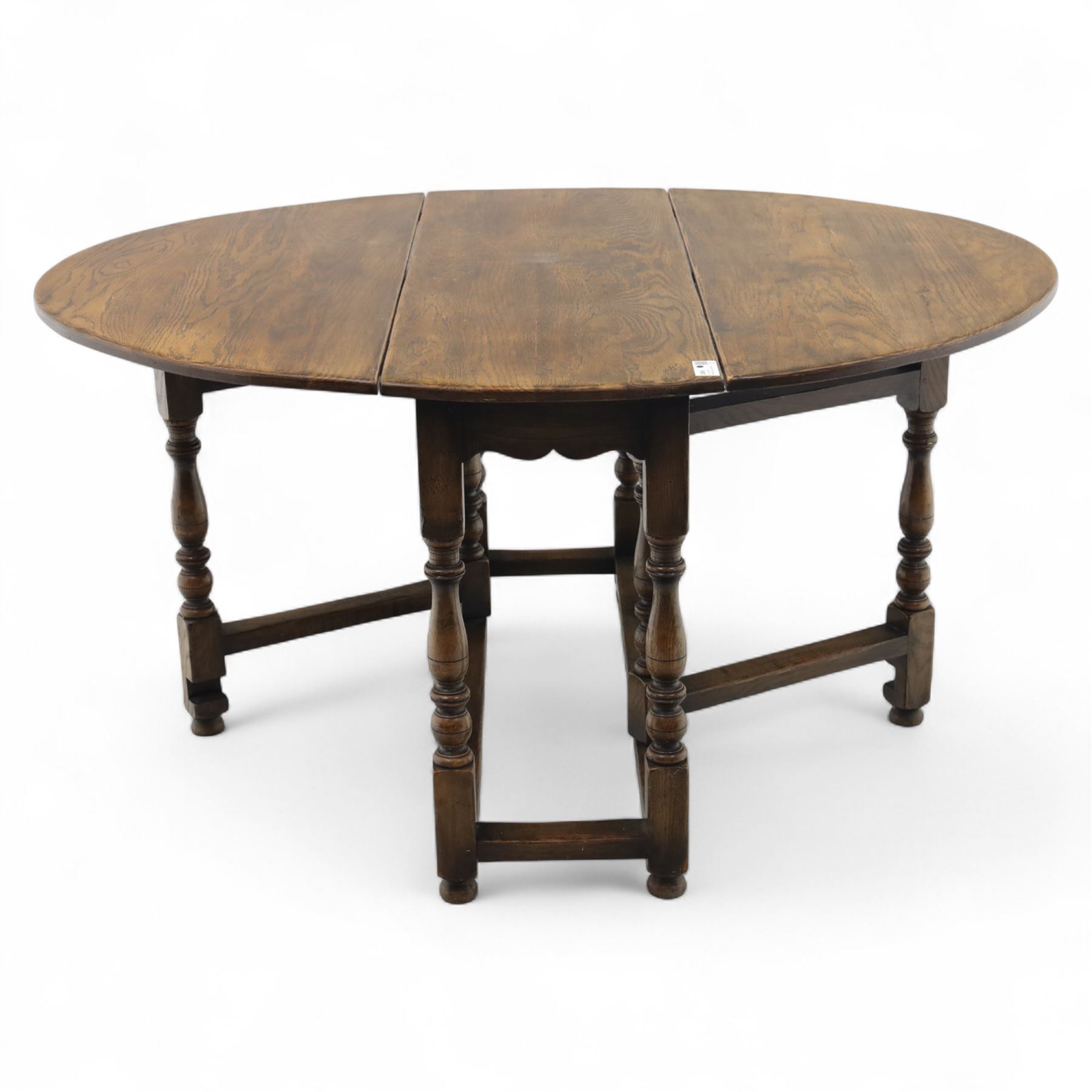 17th century design oak gateleg dining table, oval drop-leaf top on baluster turned supports, twin swinging gate legs united by peripheral stretchers (Extends to 149cm)