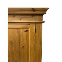 Solid pine double wardrobe, projecting moulded cornice over two panelled doors, on skirted base