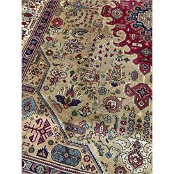 Persian Azarbaijan golden ground carpet, the shaped crimson ground medallion decorated with geometric motifs, the field profusely decorated with stylised plant and flower head motifs, repeating border with guard bands 