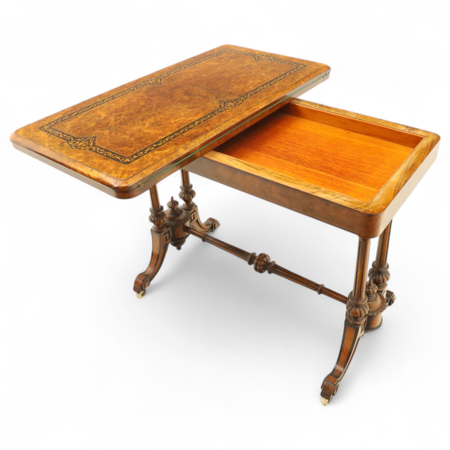 Victorian walnut and inlaid games table, rectangular fold-over top with figured walnut veneers and foliate inlay, swivel and fold over to reveal a green baize lined playing surface, on twin supports united by a stretcher, raised on scroll carved feet with castors (extended 96cm x 92cm)