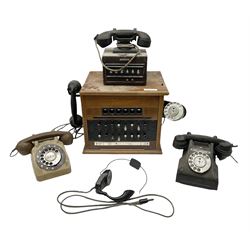 Early-mid 20th century internal telephone system, comprising exchange box with attached TMC rotary telephone and dictograph with Bakelite handset and support upon stained wood case, and 1960s black Bakelite telephone model 312L with G.P.O sticker beneath, largest H30.5cm W36.5cm D30cm