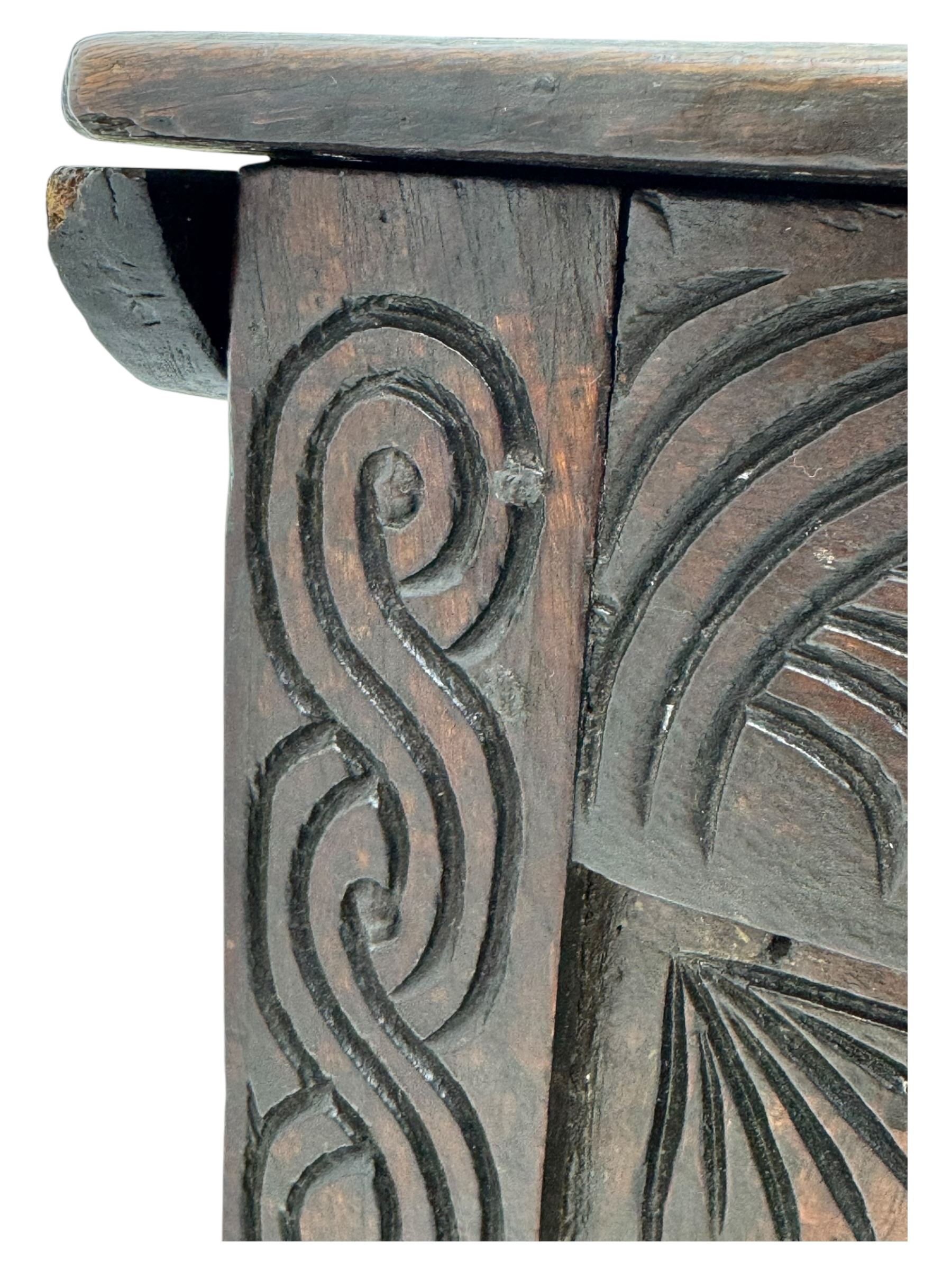 English carved oak coffer, hinged rectangular lid with indented side edges, internal candle-box, front with three-panel front with decorative carvings, raised on stile feet, circa 1700